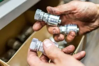 Greasy hands holding fittings